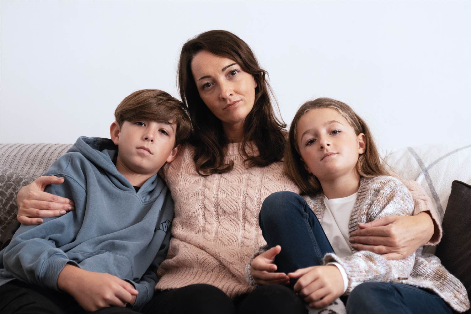 A woman sitting with her two children on either side