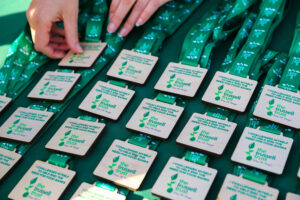 A pair of hands arranges Trussell Trust medals on a table.